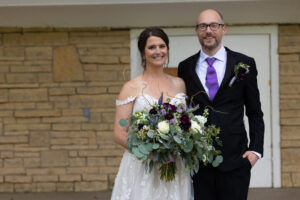 a man and a woman standing in front of a wedding dress