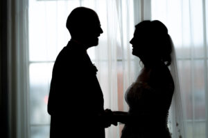 a man and a woman standing in front of a window